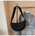 Detalle de un bolso de media luna acolchado negro con diseño de rombos y correa ajustable - Negro