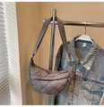 Macro view of a quilted dark grey crescent bag with wide adjustable shoulder strap - Gray