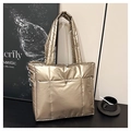 Dettaglio ravvicinato della borsa tote trapuntata con finitura metallica e chiusura magnetica - Champagne