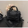 Close-up of black quilted Boston bag with litchi texture and metallic dual zippers - Black