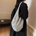 Silver-grey knitted star pattern shoulder tote bag shown on a model in a casual setting - Silver