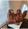 Detail view of brown suede bag with multiple zippers and decorative metal rivets - Brown