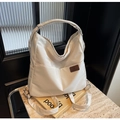 Detail of white nylon hobo bag with side pockets and fashion leather label on stone desk - Off White