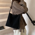 Large black suede tote bag with minimalist shoulder straps shown in a commuter style - Black