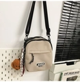 Detail of beige nylon crossbody bag with zipper pocket and cute teddy bear charm - With Charm / Khaki