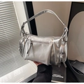 Close-up of metallic silver underarm bag featuring decorative zippers and mirror finish - Silver