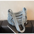 Détail du sac bandoulière en denim bleu clair avec plusieurs poches zippées devant - Bleu clair