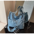 Detailansicht der hellblauen Denim-Tragetasche mit Dekotaschen und verstellbarem Riemen - Hellblau
