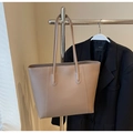 Detail of minimalist beige tote bag with slim shoulder straps and high-quality leather texture - Khaki