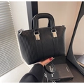 Macro detail of black litchi grain Boston bag with vertical embossed texture and silver hardware - Black