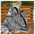 Leopard print canvas tote bag with black handles displayed on a wooden park bench - Leopard White