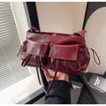 Dettaglio della borsa bowling bordeaux con fiocco e tasche frontali plissettate - Rosso