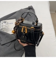 Nahaufnahme einer schwarzen Vintage-Kosmetiktasche mit goldenen Details und Anhängern - Schwarz