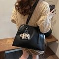 Detail einer schwarzen Kunstleder-Tote Bag mit einem süßen Plüsch-Hundeanhänger - Schwarz mit Anhänger