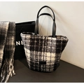 Detail of black and white houndstooth tweed texture on stylish winter tote bag - Black