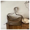 Detail der dunkelbraunen Vintage-Tasche mit Kordelzug und gealterter Lederstruktur auf Holz - Braun