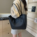 Borsa tote in pelle nera martellata con spalline lunghe indossata in un interno moderno - Nero