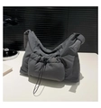 Detail view of dark grey padded nylon shoulder bag with drawstring pocket and knotted strap - Gray
