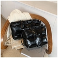 Detail view of glossy black quilted tote bags in two sizes on a stylish wooden chair - Black Large