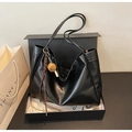 Dettaglio della borsa tote nera in ecopelle in una confezione regalo con ciondolo - Nero con ciondolo
