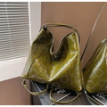 Detail der olivgrünen Hobo-Tasche mit silbernen Nietenzirkeln und glatter Ledertextur - Grün