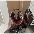 Detailansicht der großen dunkelbraunen Hobo-Tasche mit runden silbernen Nietendekoren - Braun