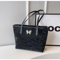 Dettaglio borsa tote nera con texture increspata e decoro a farfalla in metallo argento - Nero