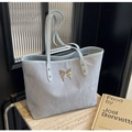 Dettaglio borsa shopper azzurra con ciondolo a farfalla e trama a sassolino - Blu