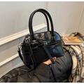 Detalle del bolso de mano negro brillante con herrajes plateados y bandolera - Negro