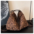 Dettaglio della borsa tote leopardata con manici in pelle e finiture in ottone dorato - Stile con Stampa Leopardata Wild di Moda / Stampa leopardata