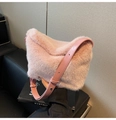 Detailansicht der rosa Plüsch-Schultertasche mit glänzendem PU-Gurt auf schwarzem Sofa - Rosa