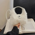 White faux fur bucket bag featuring a silver metal twist lock and thin top handle - White