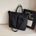 Large black utilitarian tote bag with multiple pockets and adjustable shoulder strap - Black