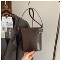 Detail of dark brown bucket bag with glossy synthetic leather and silver metal buckle - Brown