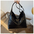 Détail d'un sac hobo noir en cuir plissé mat avec une large bandoulière réglable - Noir