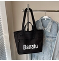 Dettaglio della borsa tote in tela nera con doppi manici e tasca frontale con zip - Nero senza Ciondolo