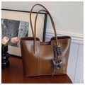 Close-up of brown faux leather tote bag with white contrast stitching and cat charm - With Charm / Brown