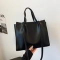 Minimalist black faux leather tote bag with sturdy handles and a detachable shoulder strap - Black