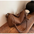 Détail du sac polochon en cuir plissé marron caramel montrant la forme et les sangles - Marron