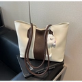 Detalle de un bolso tote grande bicolor crema y marrón con un colgante de pompón blanco - Blanco Crema Con Colgante
