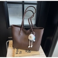 Detalle del bolso tote de cuero sintético marrón con un colgante de peluche - Café con Colgante