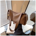 Detail of brown litchi pattern leather cylinder bag with wide strap and gold hardware - Coffee