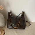 Minimalist deep coffee tote bag with gold chain strap and metallic branding detail - Brown