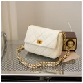 Détail du cuir matelassé beige et du fermoir tournant doré sur un sac à bandoulière - Verrou carré / Blanc Cassé