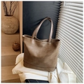 Dettaglio della grande borsa tote in ecopelle marrone su un elegante blazer bianco - Sabbia