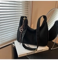 Minimalistische schwarze Nylon Hobo Bag auf weißem Buch mit modernem Anhänger-Detail - Schwarz