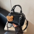 Glossy black bowling handbag with textured faux leather and cute plush bear charm - Black