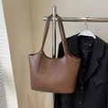 Vintage brown leather tote bag with silver buckle on a hanger next to a black blazer - No Pendant / Brown