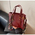 Dettaglio borsa a secchiello bordeaux in pelle PU con ciondolo a abaco dorato e anello - Rosso Ankora Con Ciondoli