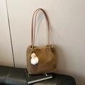 Brown fleece tote bag with leather strap and baby face plush charm on a black book - Brown